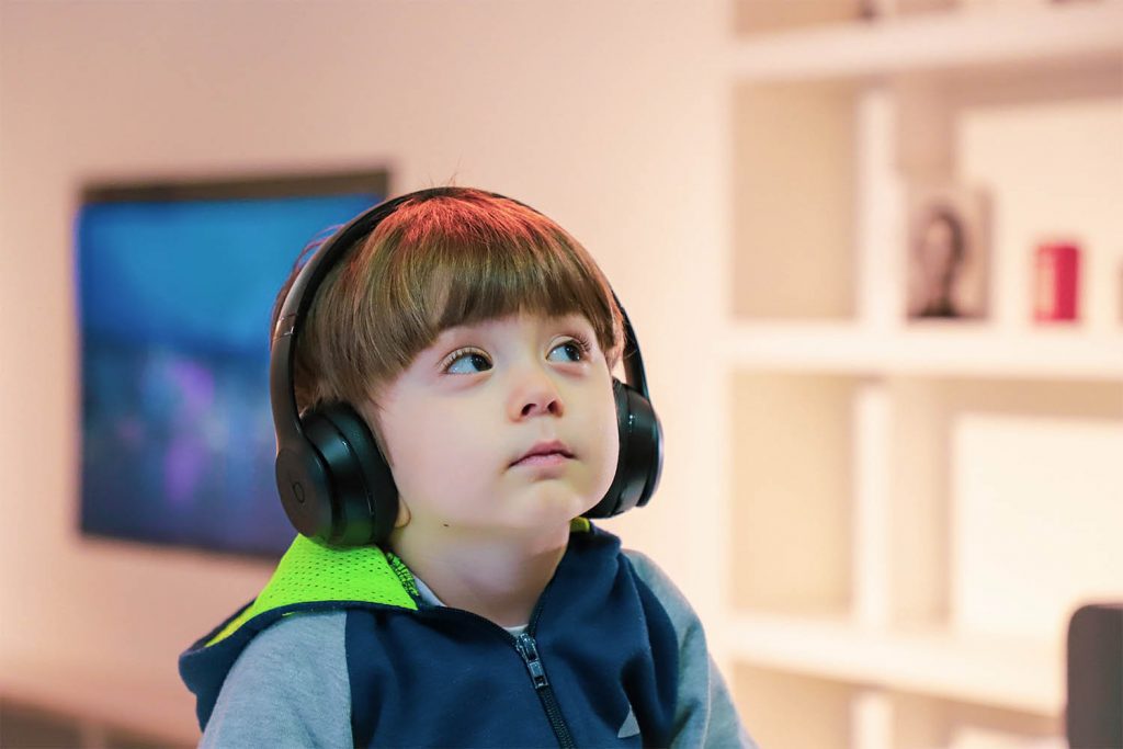 Young boy wearing headphones listenign to calming sounds