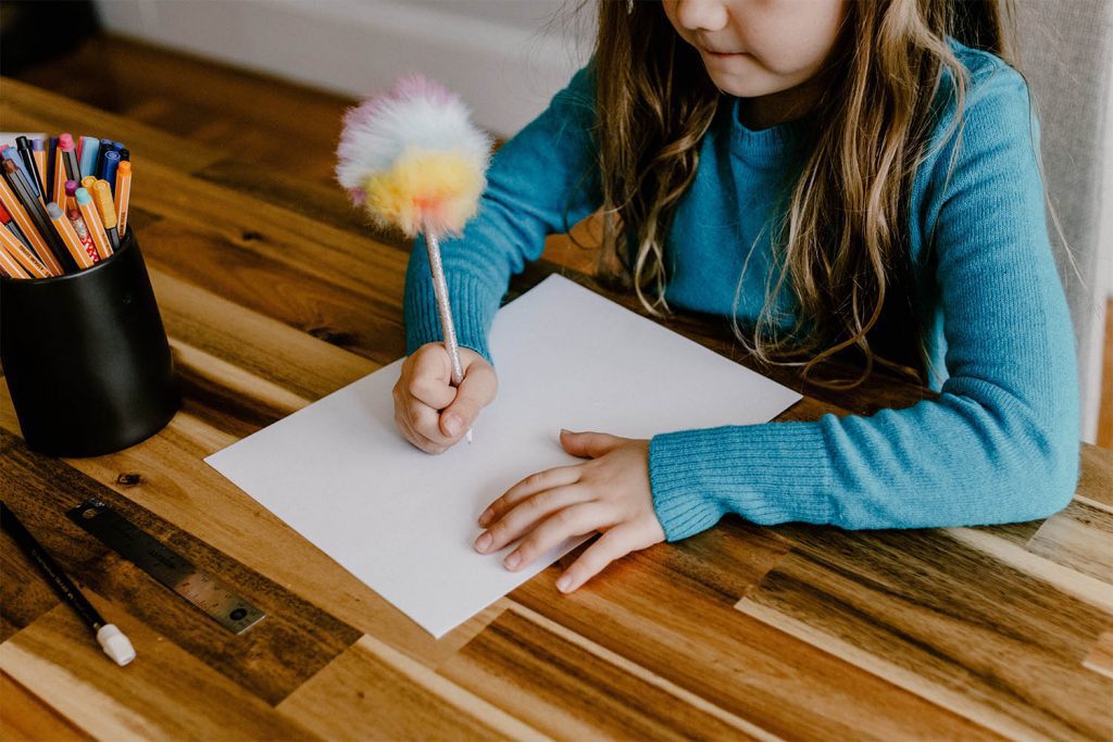 Child planning a list of items they would like to take on holiday with them