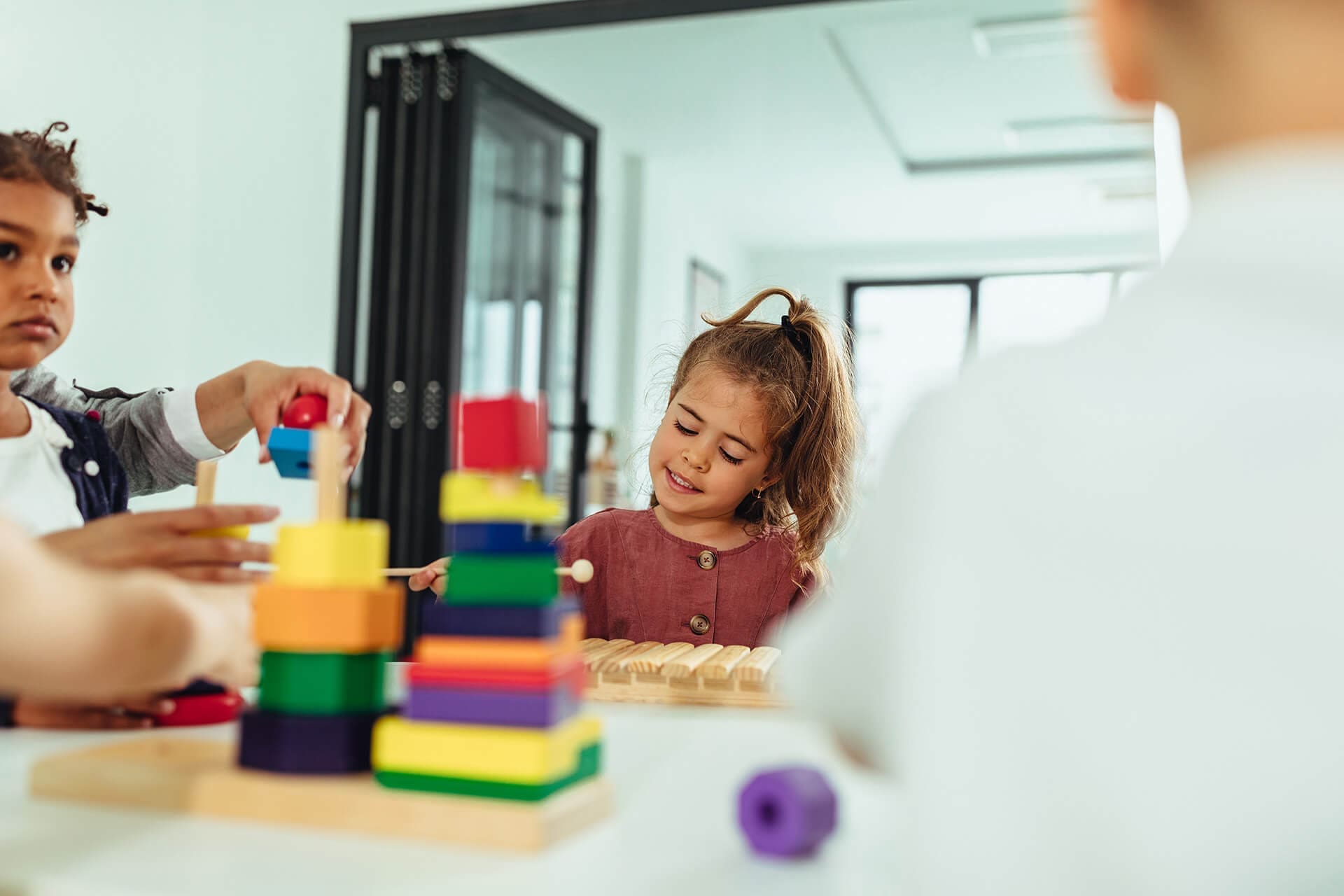 A young girl plays with the xylophone during a group therapy session.