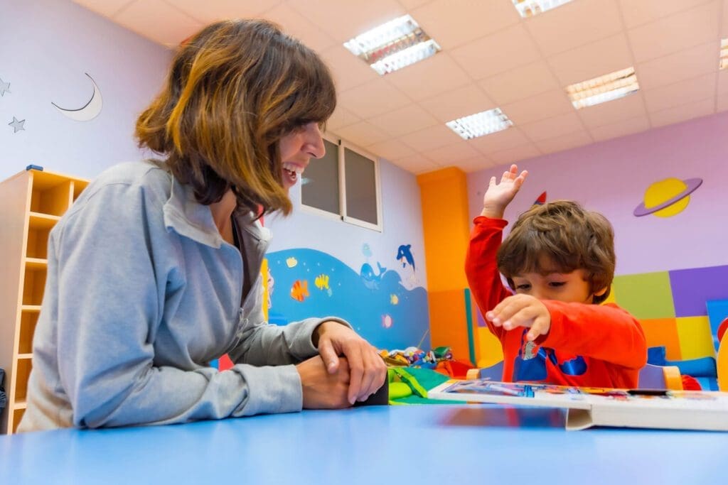 A young boy and speech therapist in a brightly colored room